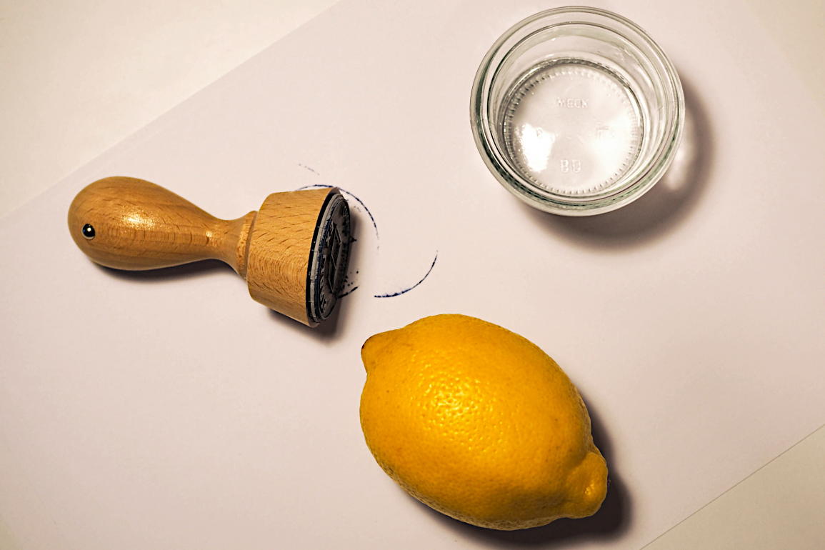 Stempelfarbe von Textilien entfernen Holzstempel rund, Stempelfarbe auf Papier, Zitrone und Zitronensaft im Schälchen